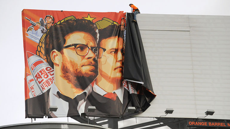 Workers remove a poster-banner for "The Interview" from a billboard in Hollywood. (Michael Thurston/AFP/Getty Images)